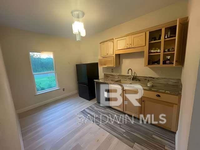 21800 Old Brady Rd, Robertsdale, AL 36567 - kitchen with freestanding refrigerator, a sink, light wood-type flooring, and baseboards