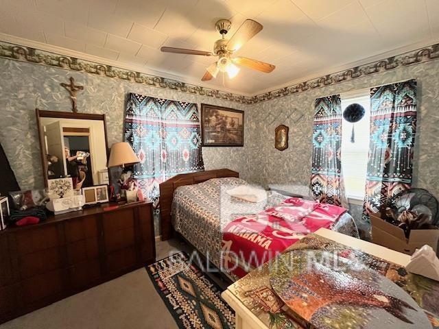 bedroom featuring ceiling fan and ornamental molding