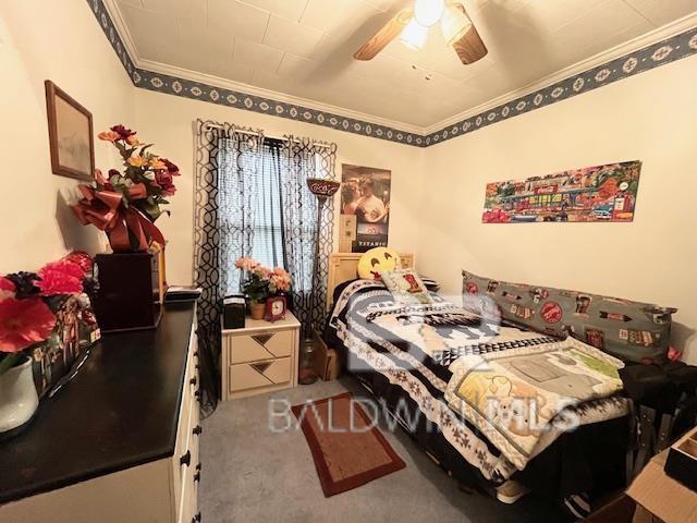 carpeted bedroom with ceiling fan and crown molding