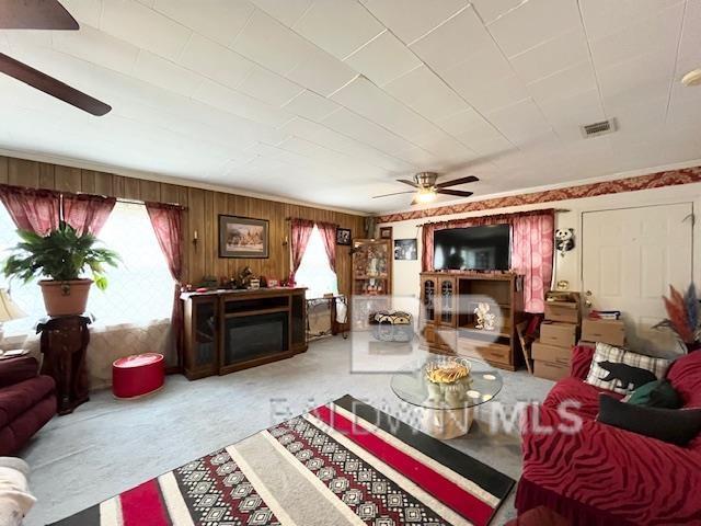 carpeted living room featuring ceiling fan and a fireplace