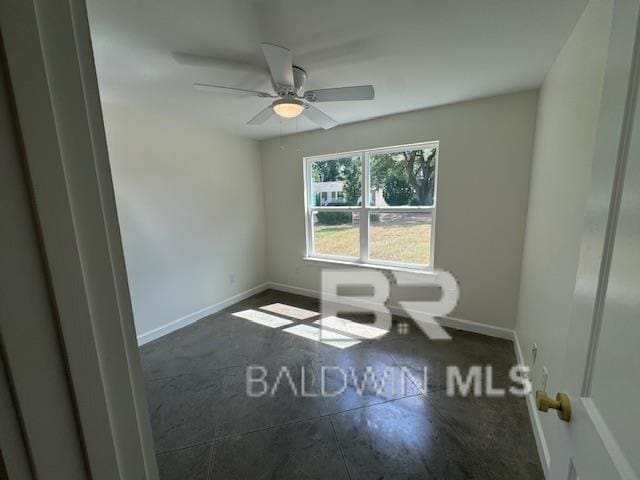 tiled spare room featuring ceiling fan