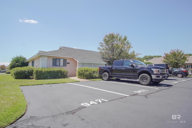 view of car parking featuring a lawn