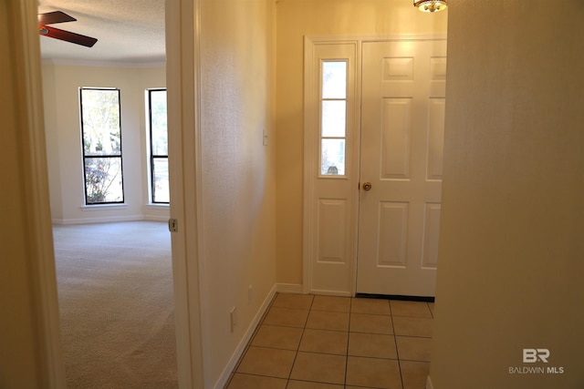 carpeted entryway with a textured ceiling and ceiling fan