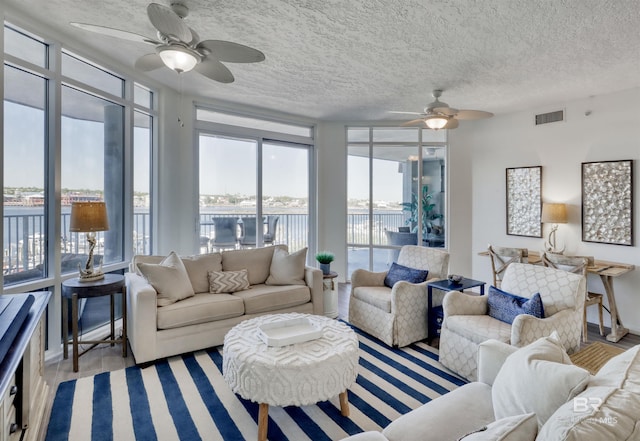27405 Polaris St Unit 302, Orange Beach, AL 36561 - living area with a ceiling fan, a textured ceiling, a water view, and wood finished floors