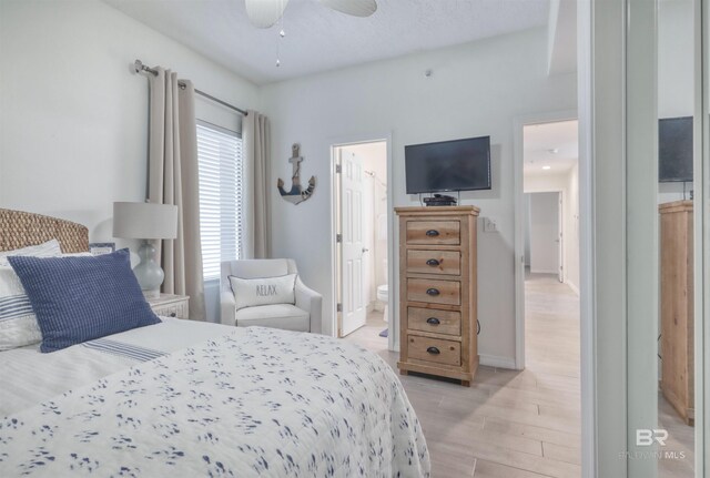 27405 Polaris St Unit 302, Orange Beach, AL 36561 - bedroom with light wood-style floors, ensuite bathroom, and baseboards