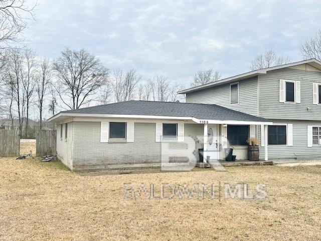 rear view of house featuring a lawn