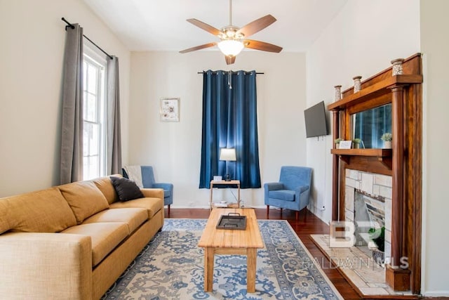 living room featuring ceiling fan, dark wood-type flooring, and a fireplace