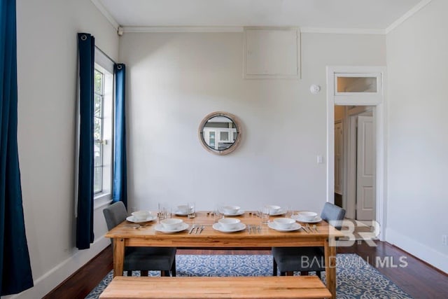 dining area featuring ornamental molding and dark hardwood / wood-style floors