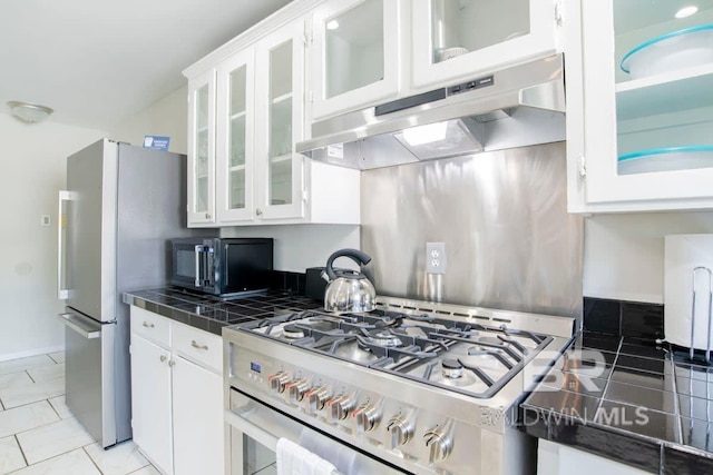 kitchen with white cabinets, stainless steel appliances, and light tile patterned flooring