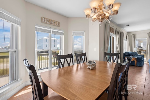 tiled dining room with a notable chandelier and visible vents