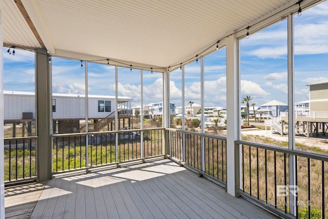 unfurnished sunroom featuring a wealth of natural light and a residential view