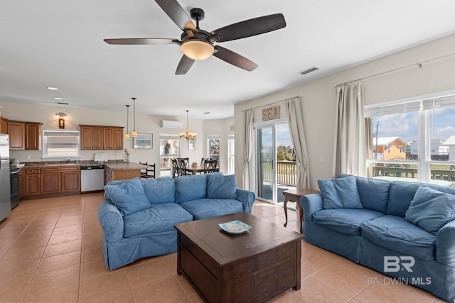 living area featuring light tile patterned flooring, ceiling fan, a wall mounted air conditioner, and visible vents