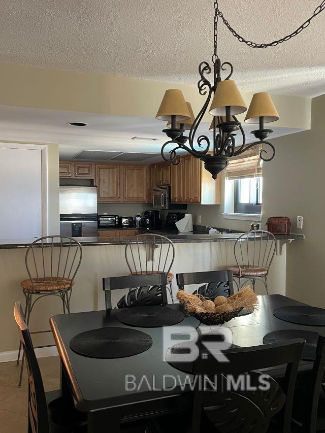 tiled dining area with a textured ceiling