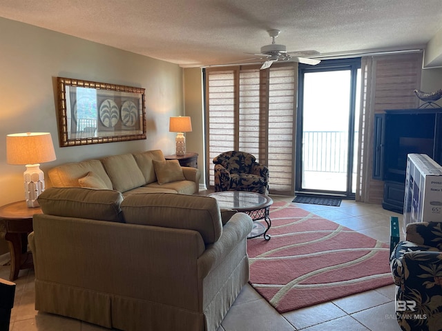 living room featuring light tile patterned floors, a textured ceiling, and ceiling fan