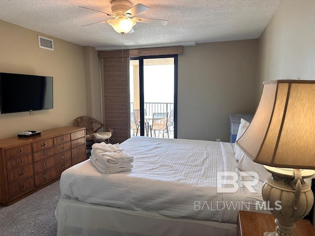 bedroom featuring ceiling fan, light colored carpet, access to exterior, and a textured ceiling