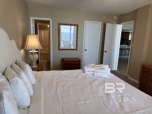 bedroom with dark colored carpet and a textured ceiling