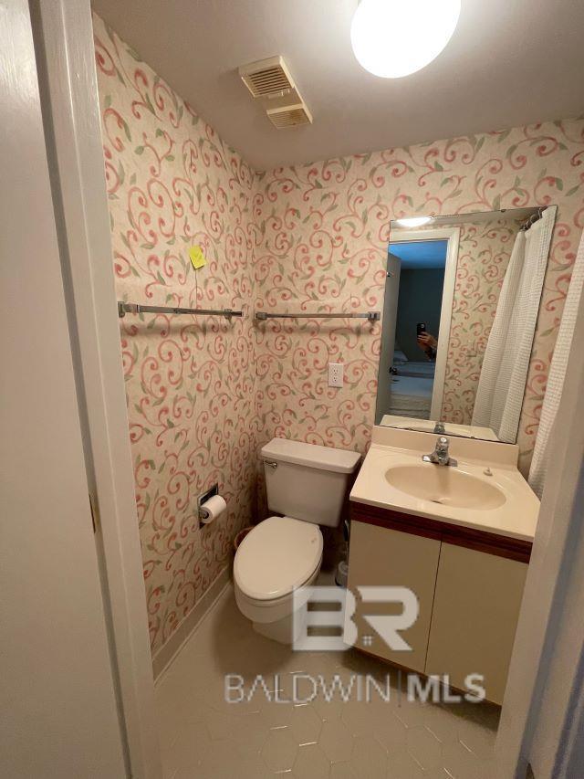 bathroom with vanity, tile patterned flooring, and toilet