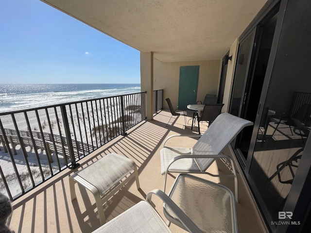 balcony featuring a water view and a view of the beach