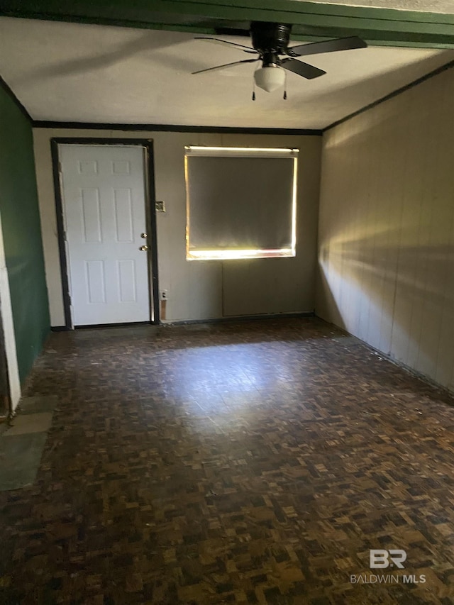 empty room featuring ceiling fan and ornamental molding