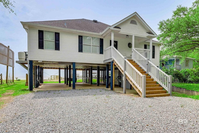 raised beach house featuring a carport and covered porch