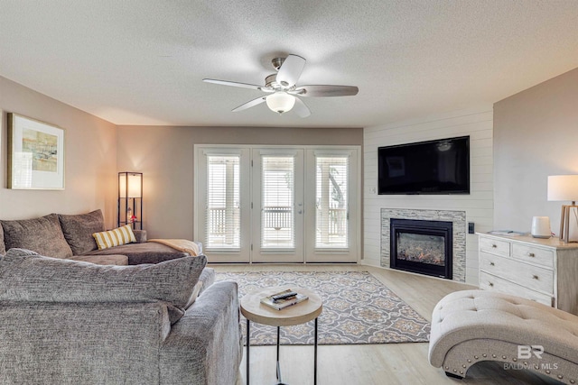 9581 S Bay Rd, Foley, AL 36535 - living room featuring light hardwood / wood-style flooring, ceiling fan, a fireplace, and a textured ceiling