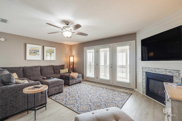 9581 S Bay Rd, Foley, AL 36535 - living room featuring a fireplace, light hardwood / wood-style flooring, a textured ceiling, and ceiling fan