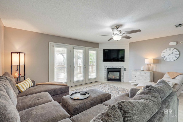 9581 S Bay Rd, Foley, AL 36535 - living room with ceiling fan, a fireplace, and a textured ceiling