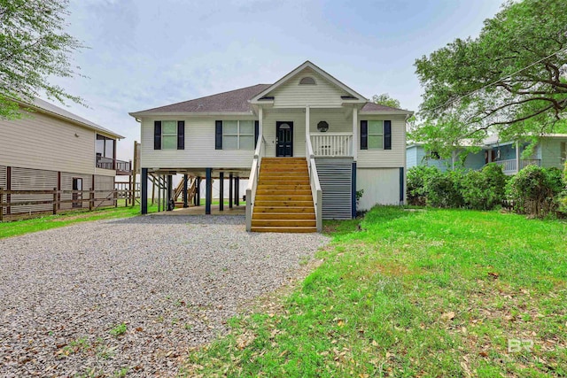 view of front of property featuring a porch, a carport, and a front yard