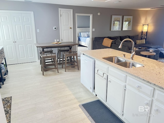 9581 S Bay Rd, Foley, AL 36535 - kitchen with light stone counters, sink, dishwasher, and white cabinets