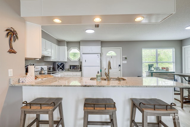 9581 S Bay Rd, Foley, AL 36535 - kitchen featuring sink, range, white cabinets, kitchen peninsula, and white fridge