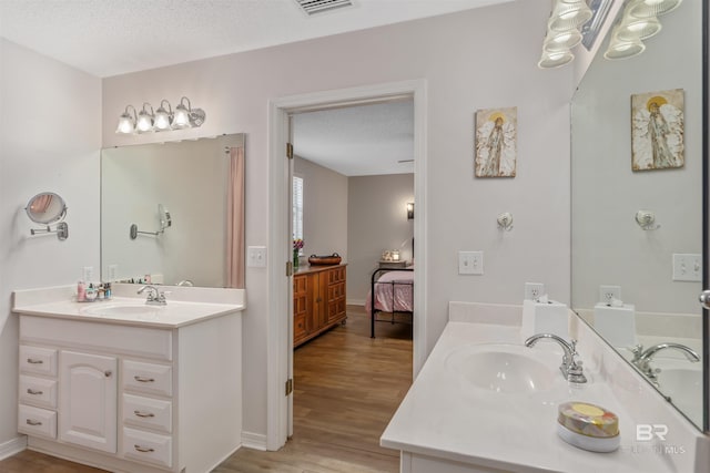 bathroom with vanity, wood-type flooring, and a textured ceiling