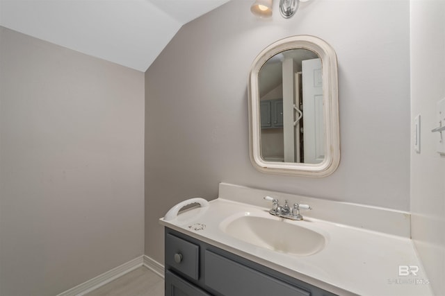 bathroom with lofted ceiling and vanity