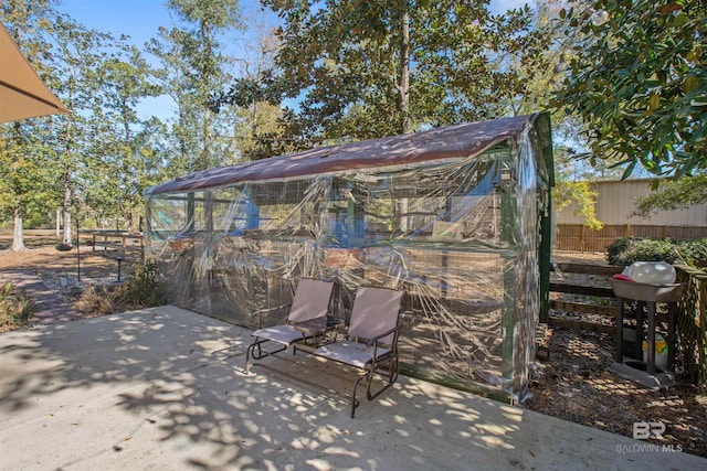 view of patio / terrace featuring a grill and an outbuilding