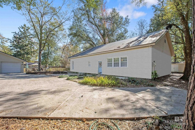 exterior space featuring an outbuilding, metal roof, and a garage