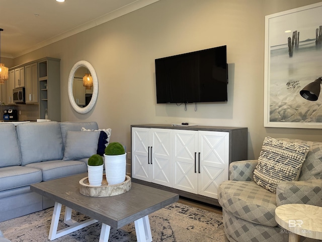 living area with a chandelier, wood finished floors, and crown molding