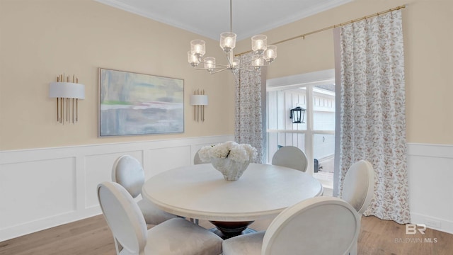 dining room with a notable chandelier, crown molding, and wood-type flooring