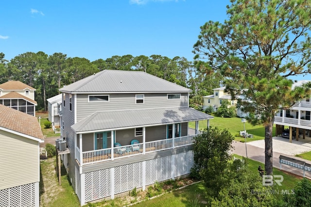 rear view of property featuring cooling unit and a lawn