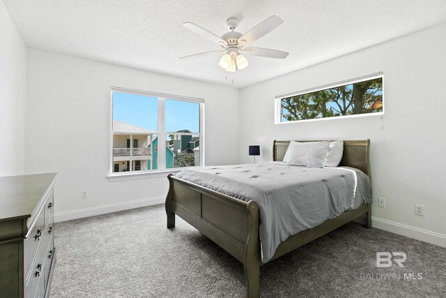 bedroom with ceiling fan, light colored carpet, and multiple windows