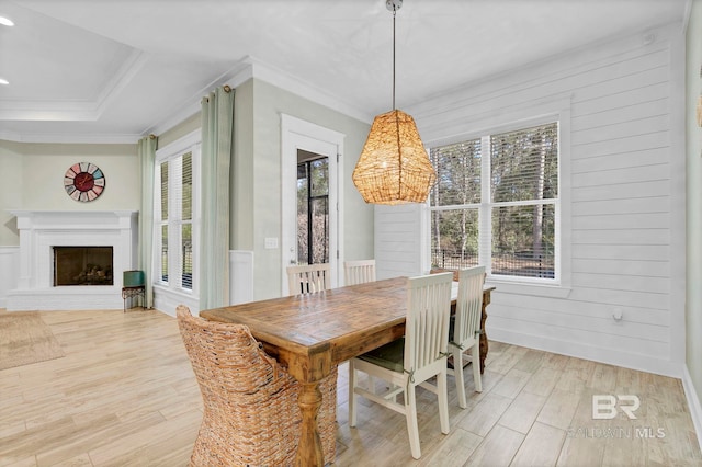 dining room featuring light wood finished floors, plenty of natural light, and crown molding