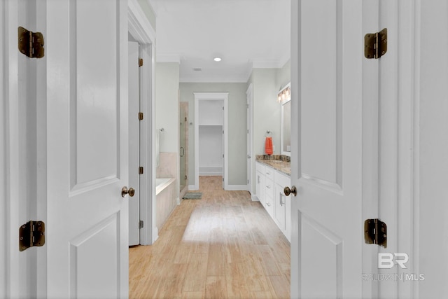 bathroom with a garden tub, ornamental molding, vanity, a shower stall, and wood finished floors