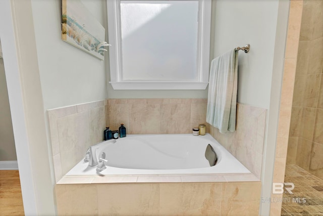 bathroom featuring a bath and tiled shower