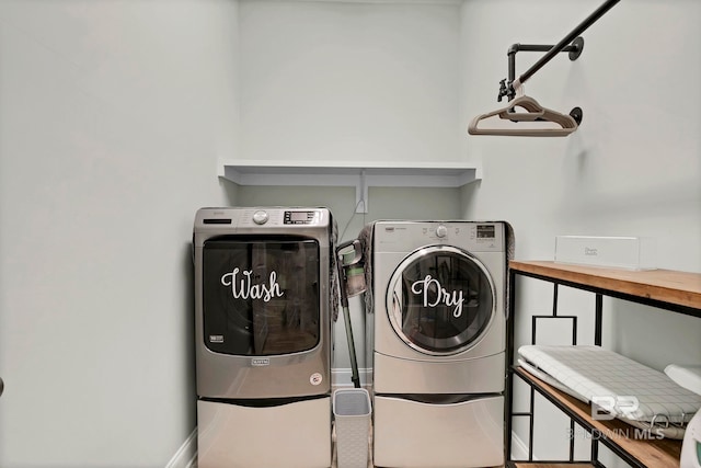 washroom with laundry area, baseboards, and separate washer and dryer