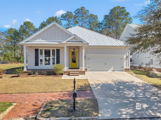 modern farmhouse style home featuring a garage, driveway, metal roof, a standing seam roof, and board and batten siding