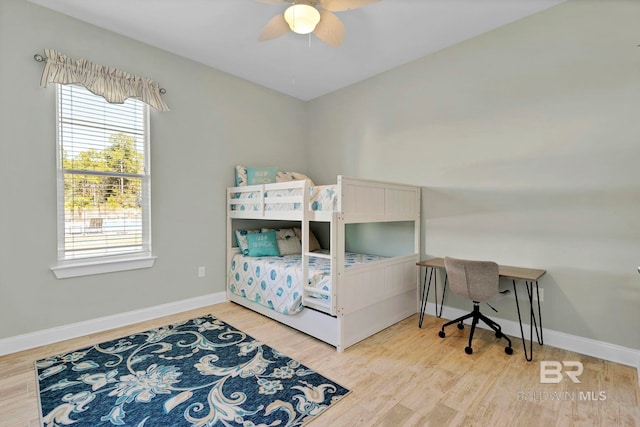 bedroom featuring a ceiling fan, baseboards, and wood finished floors