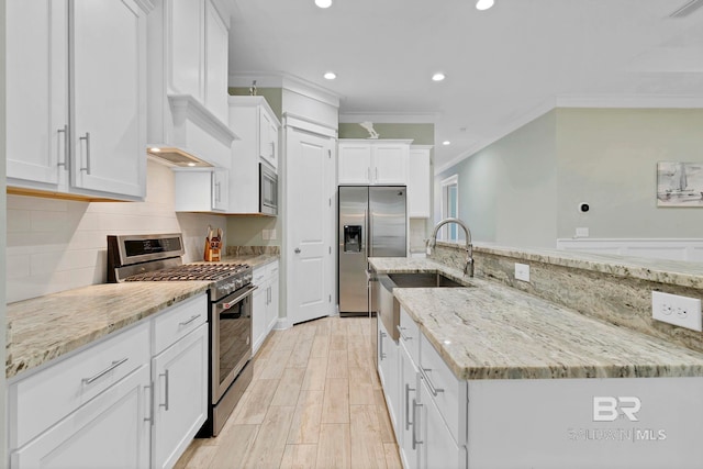 kitchen featuring tasteful backsplash, white cabinets, light stone counters, stainless steel appliances, and crown molding