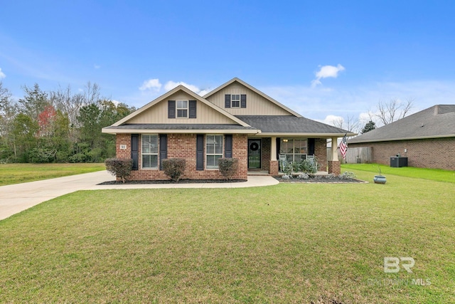 craftsman house with brick siding, central AC unit, a front yard, and roof with shingles