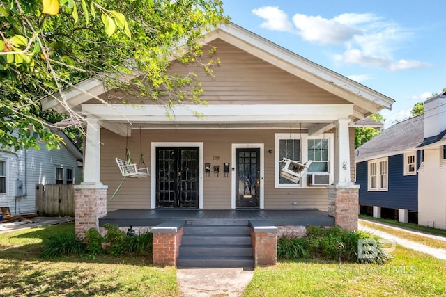 shotgun-style home with covered porch and cooling unit