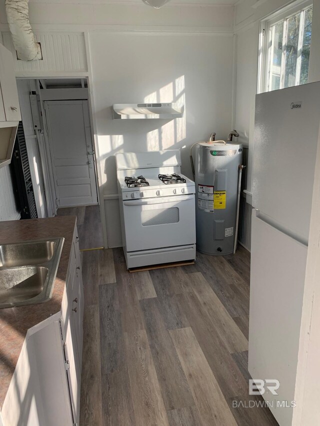 kitchen featuring dark wood finished floors, under cabinet range hood, white appliances, and electric water heater