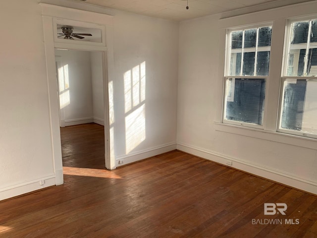 empty room featuring a ceiling fan, baseboards, and hardwood / wood-style flooring