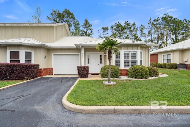 single story home with an attached garage, board and batten siding, aphalt driveway, a front lawn, and central AC